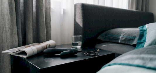 Rechargeable vibrator on nightstand with charging cable