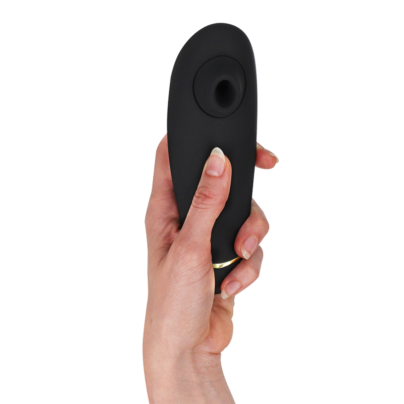 Black ergonomic clitoral stimulator with circular suction head held in hand.