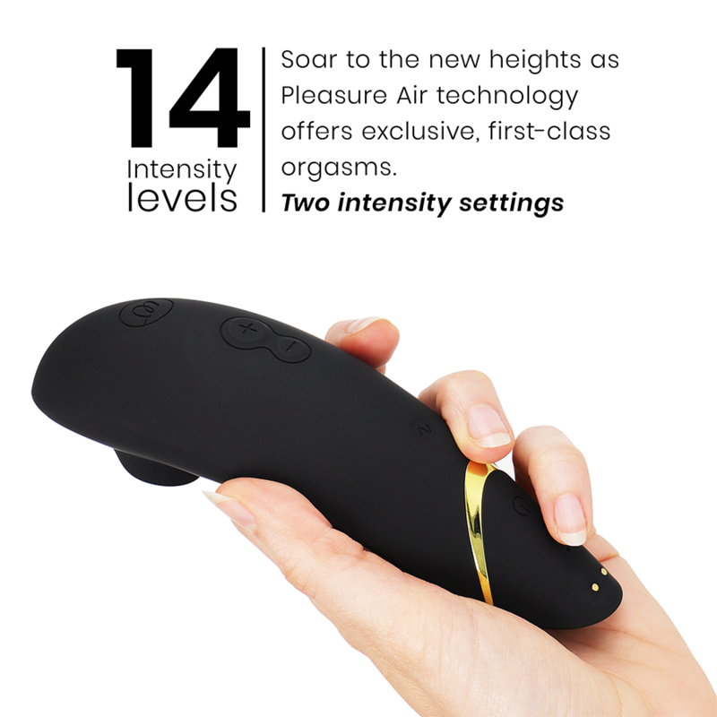 Black ergonomic clitoral stimulator with curved design and gold accent held in hand.