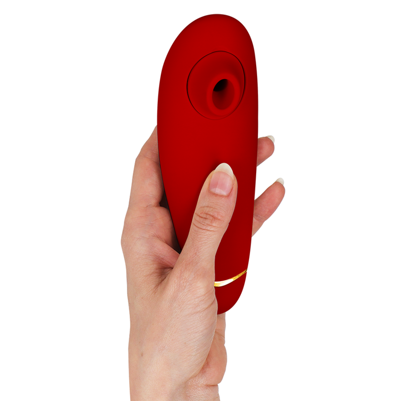 Bordeaux clitoral stimulator with smooth silicone surface held in hand, featuring a circular opening and gold accent ring.
