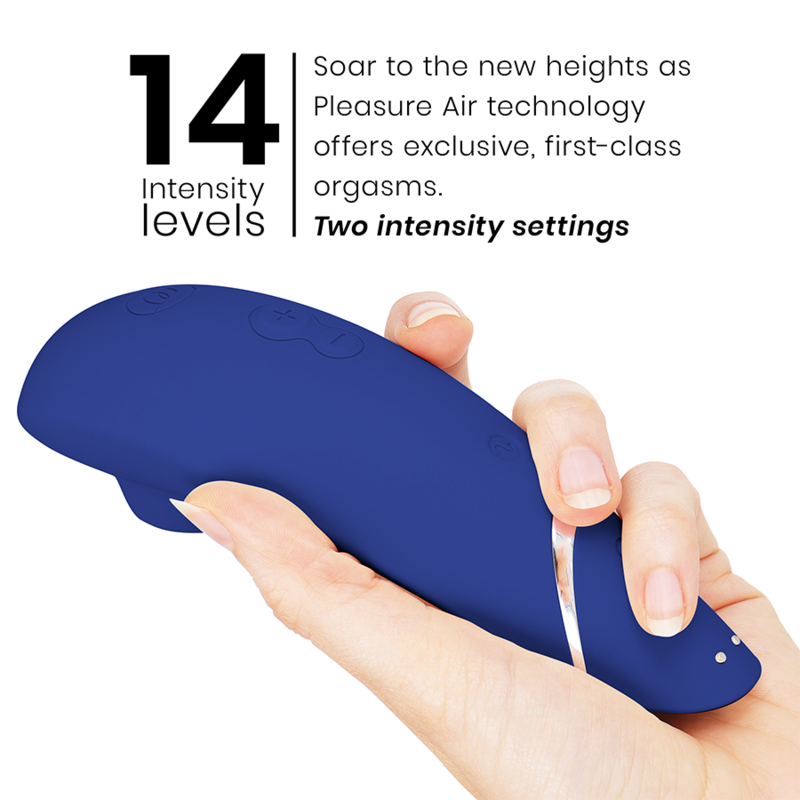 Blueberry-colored clitoral stimulator with ergonomic shape held in hand against white background.
