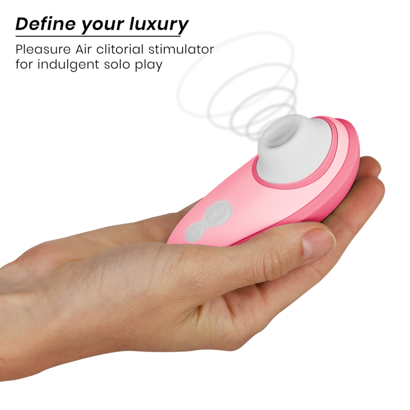 Pink Womanizer Liberty 2 clitoris stimulator with white silicone suction tip held in hand.
