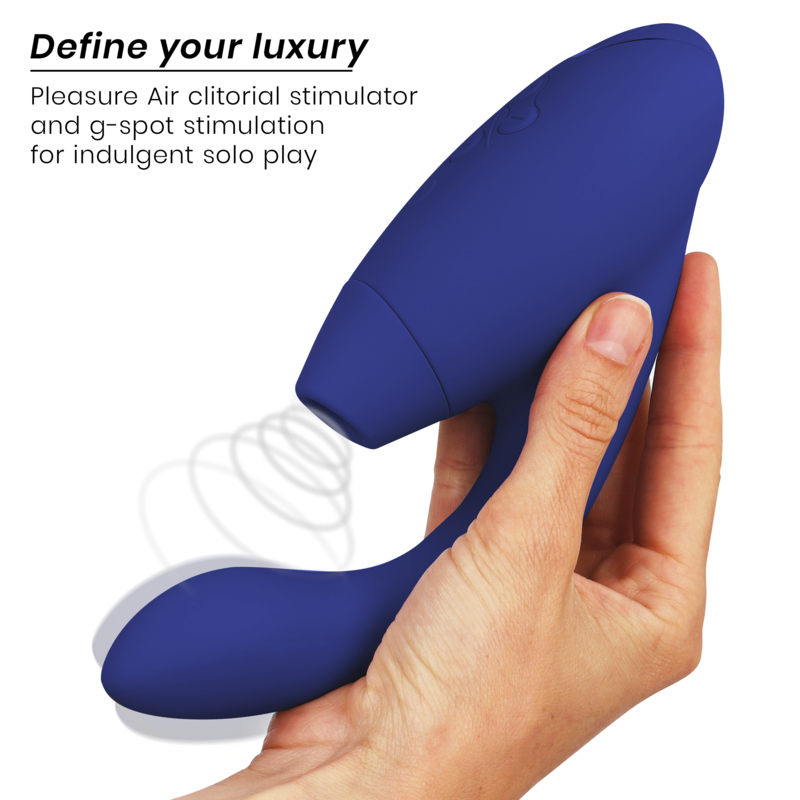 Blue dual-action clitoral and G-spot stimulator held in one hand with smooth, curved design.