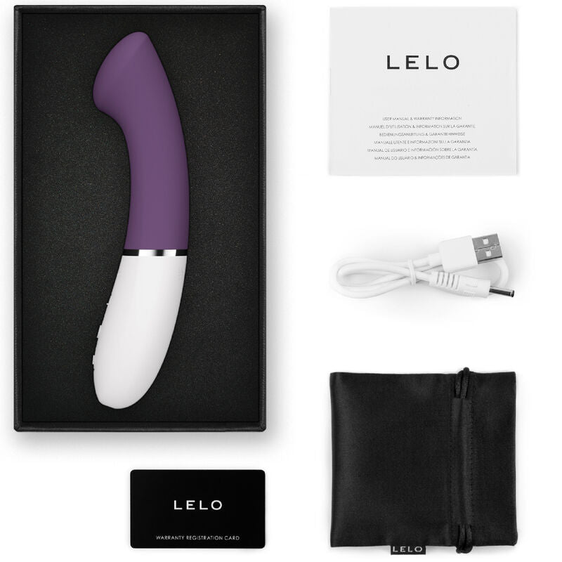 Violet curved G-spot vibrator with white base in black box, USB charging cable, storage pouch, and instruction card.