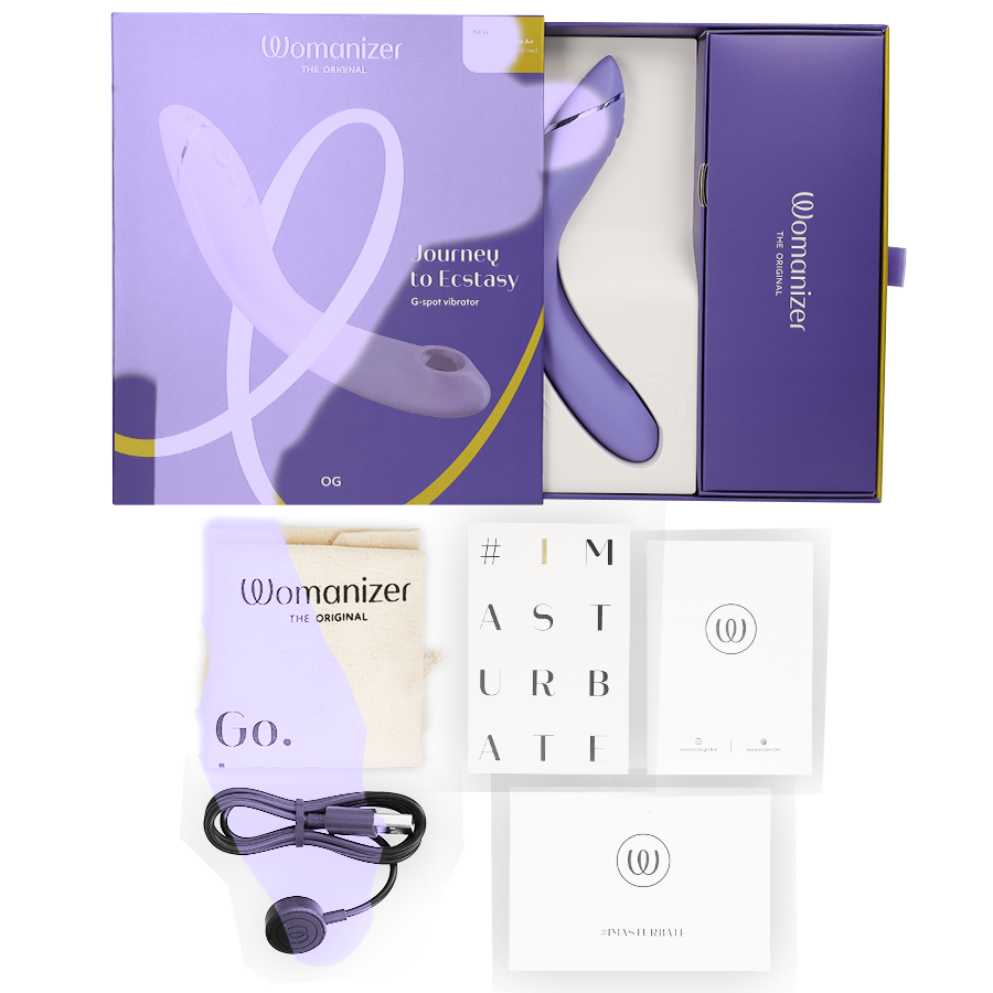 Lilac Womanizer OG G-Spot stimulator in open purple box with USB cable and instruction booklets.
