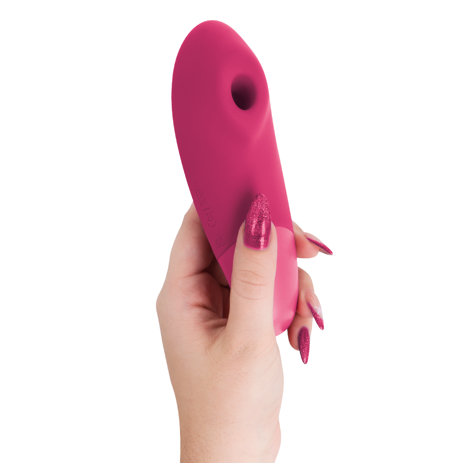 Vibrant pink clitoral stimulator with curved ergonomic design held in hand with matching pink nails.