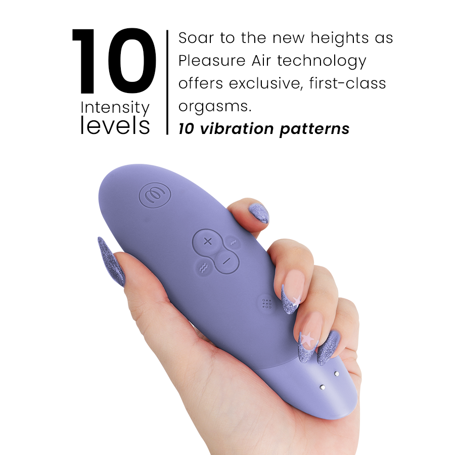 Lilac Womanizer Enhance clitoral stimulator with ergonomic shape held in hand, showing control buttons and charging ports.