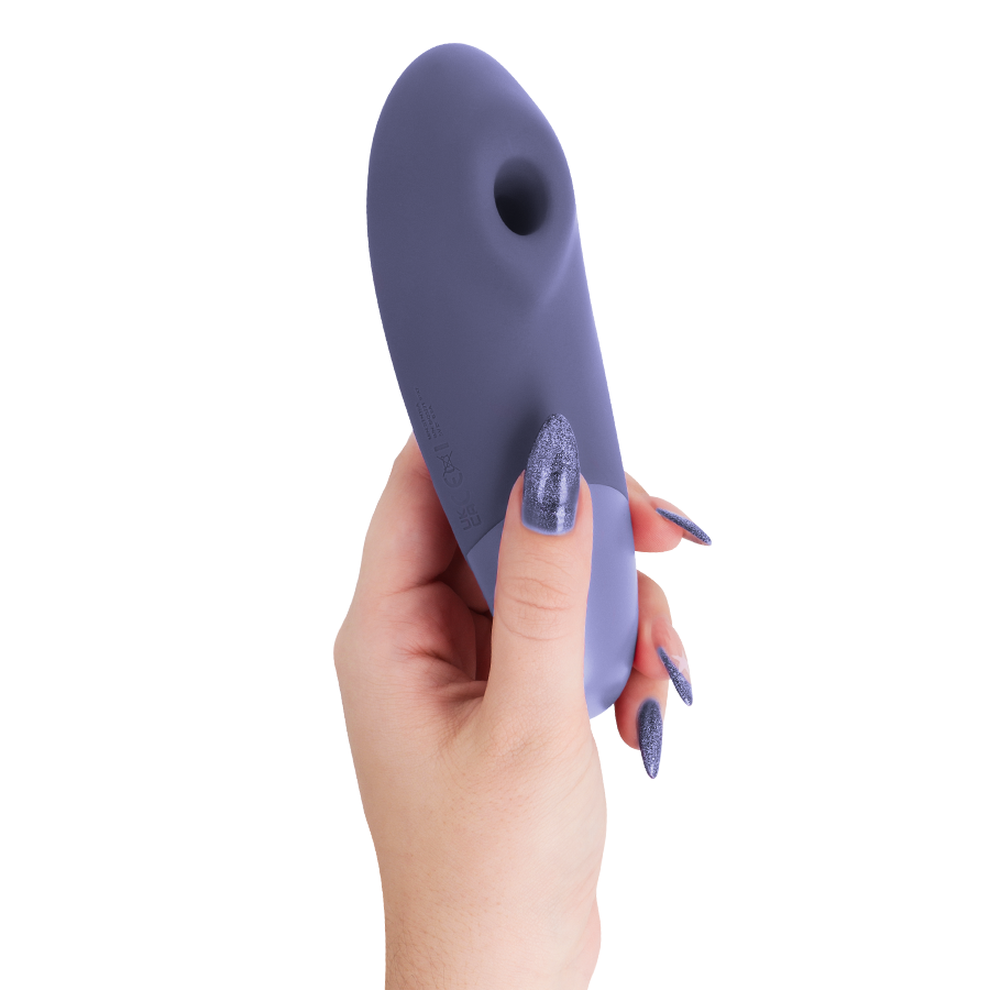 Lilac Womanizer Enhance clitoral stimulator held in hand with matching lilac nails.