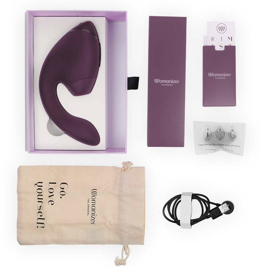 Dark purple dual clitoral and G-spot stimulator with branded box, charger, instruction manual, and beige drawstring pouch.