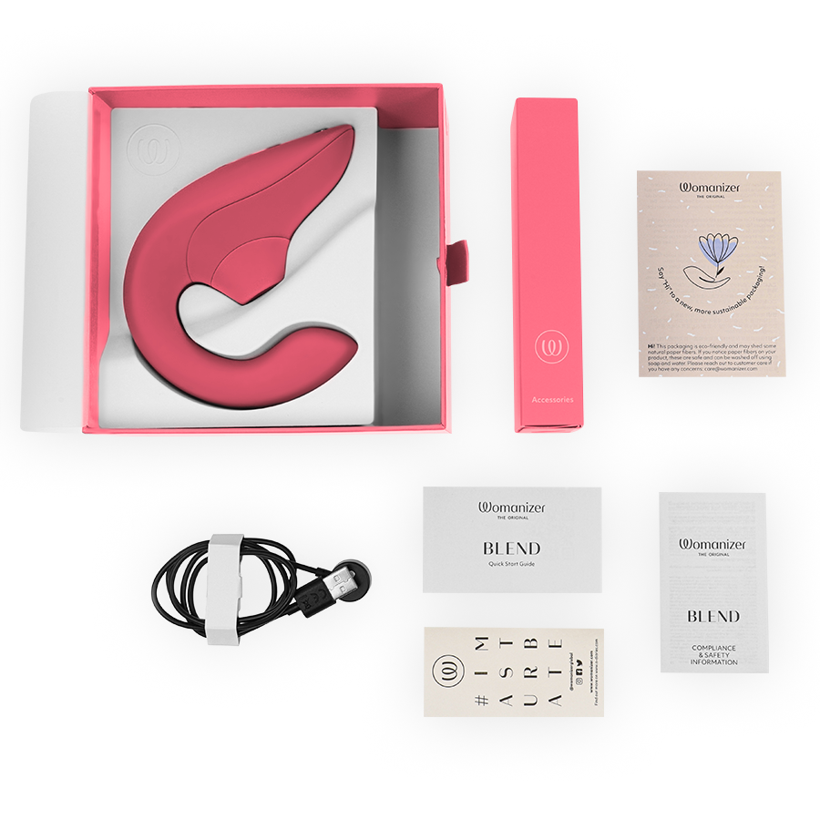Vibrant rose-colored Womanizer Blend rabbit vibrator stimulator with pink charging box, USB cable, and user manuals in open.
