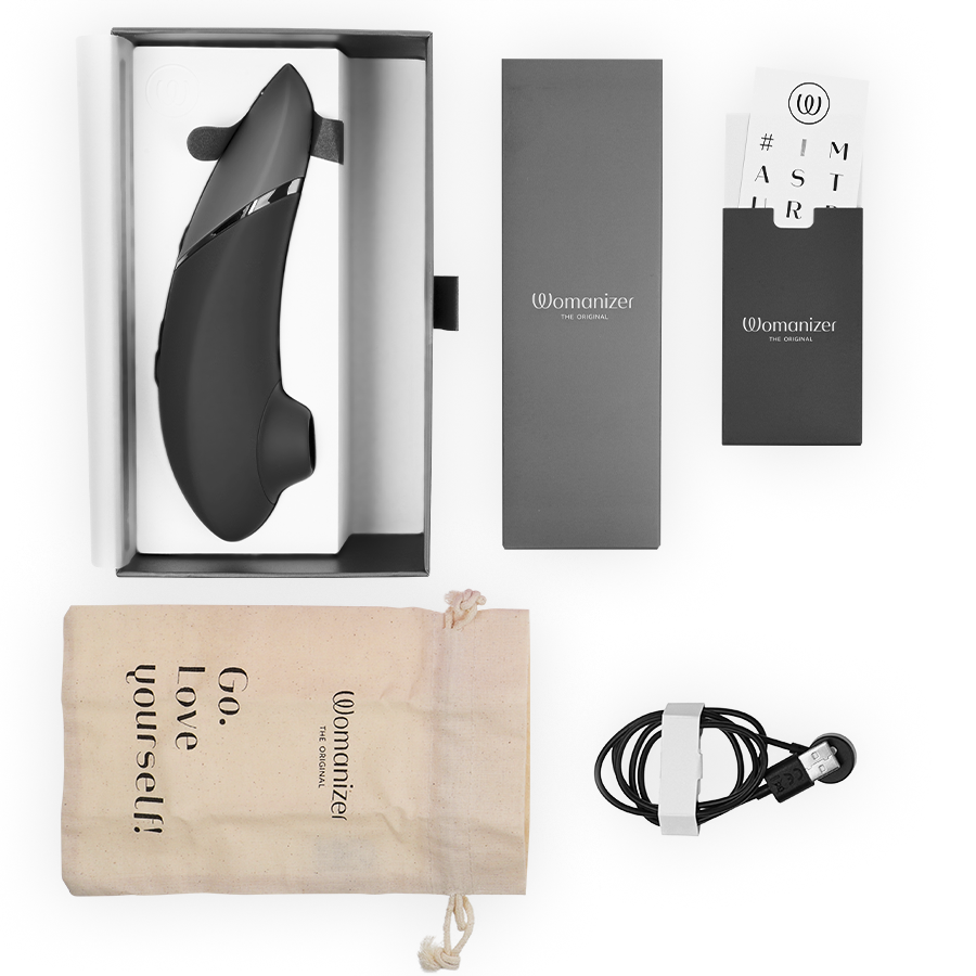 Black WOMANIZER Next clitorial stimulator with sleek curved design, packaging box, drawstring pouch, USB charging cable, and .