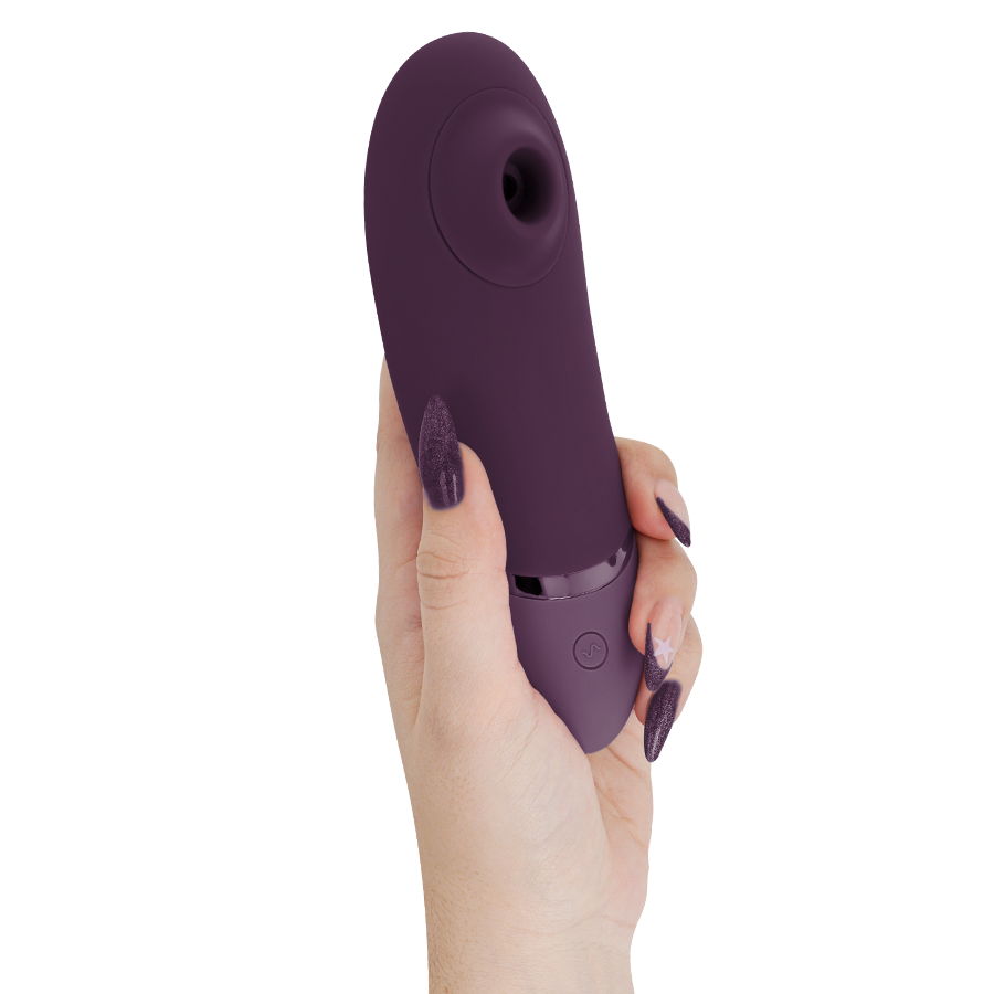 Dark purple Womanizer Next clitoral stimulator held in hand with glossy finish and control button.