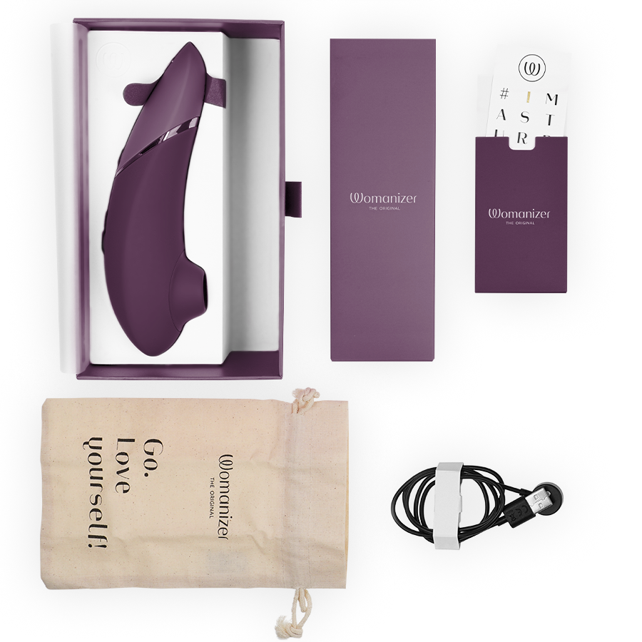 Dark purple Womanizer Next clitoral stimulator with sleek curved design, charging cable, storage pouch, and product box.